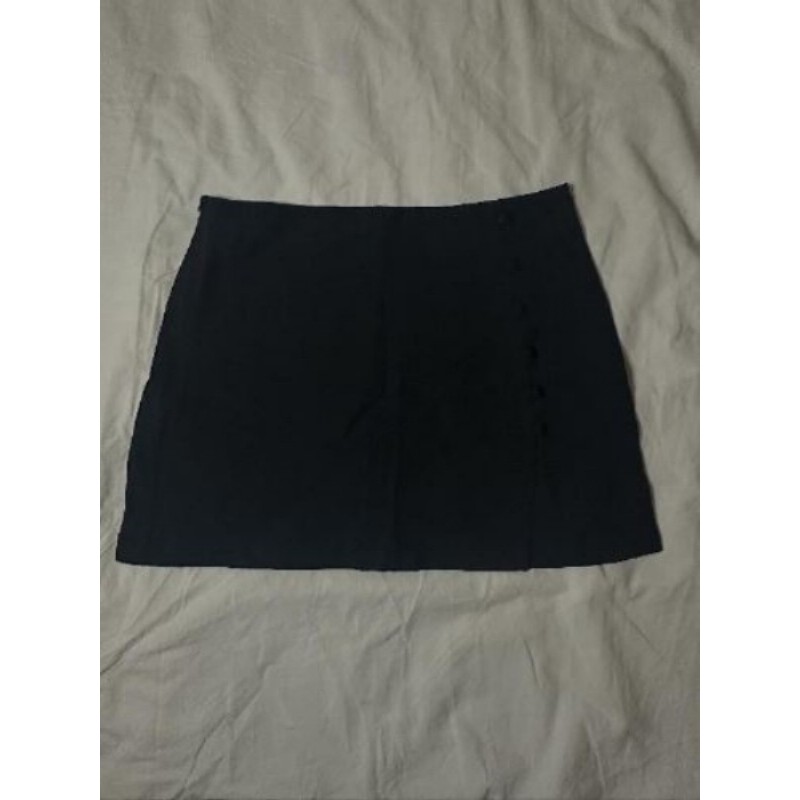 Mini jupe noire, fente et boutons à l'avant